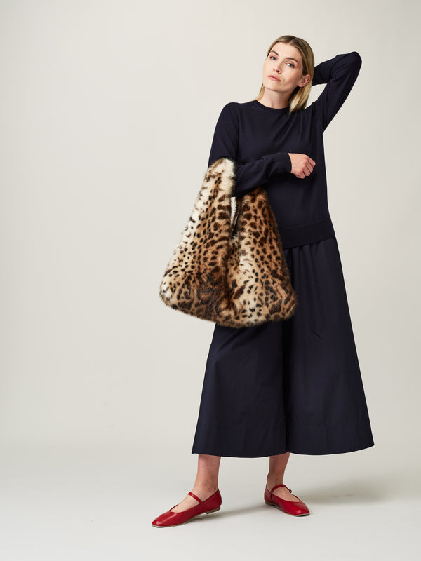 Model carrying the faux fur Ocelot Triangle Bag by Helen Moore