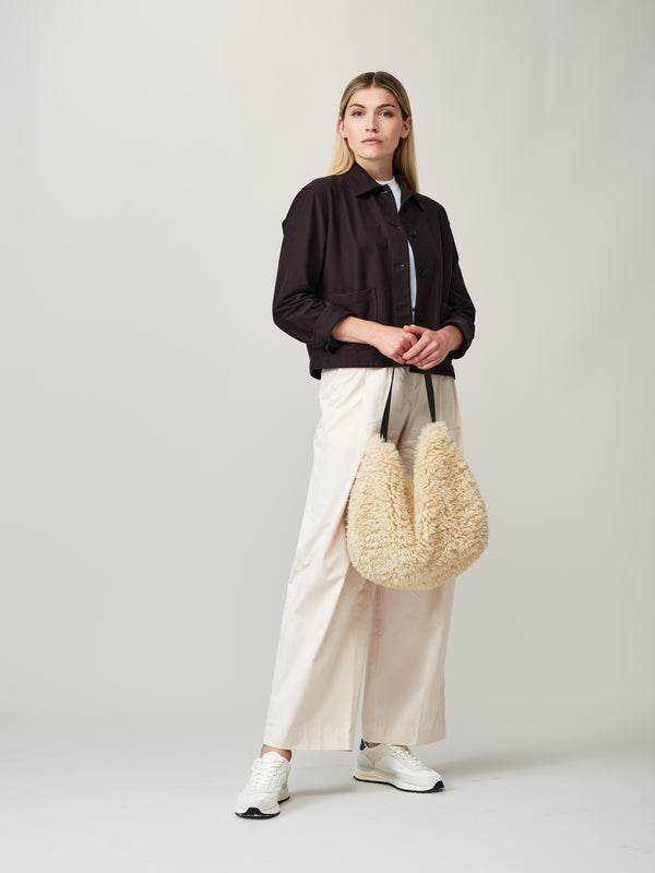 Model holding the cream faux sheepskin Slouch Bag by Helen Moore