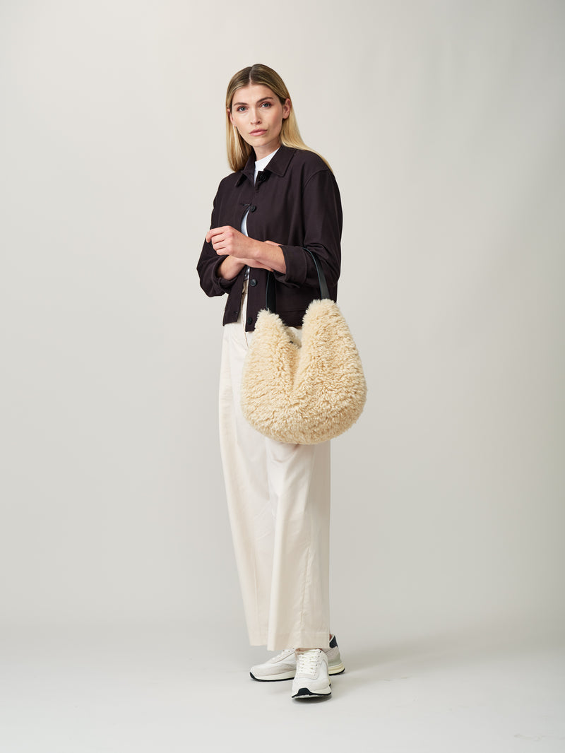 Model holding the cream faux sheepskin Slouch Bag by Helen Moore