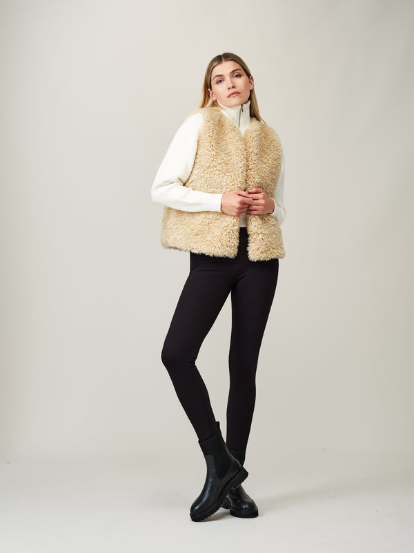 Model wearing a cream faux sheepskin gilet by Helen Moore