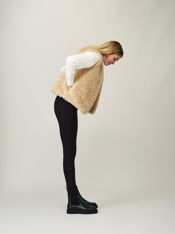 Model wearing a cream faux sheepskin gilet by Helen Moore