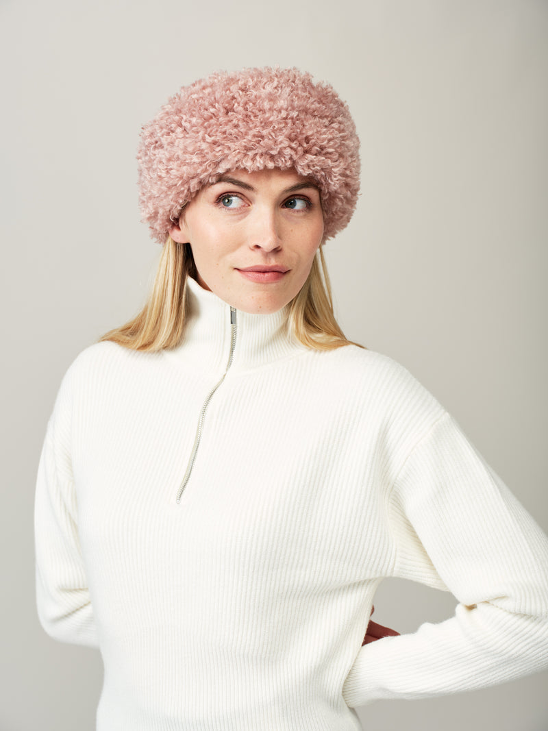 Women wearing a pink rose faux sheepskin headband