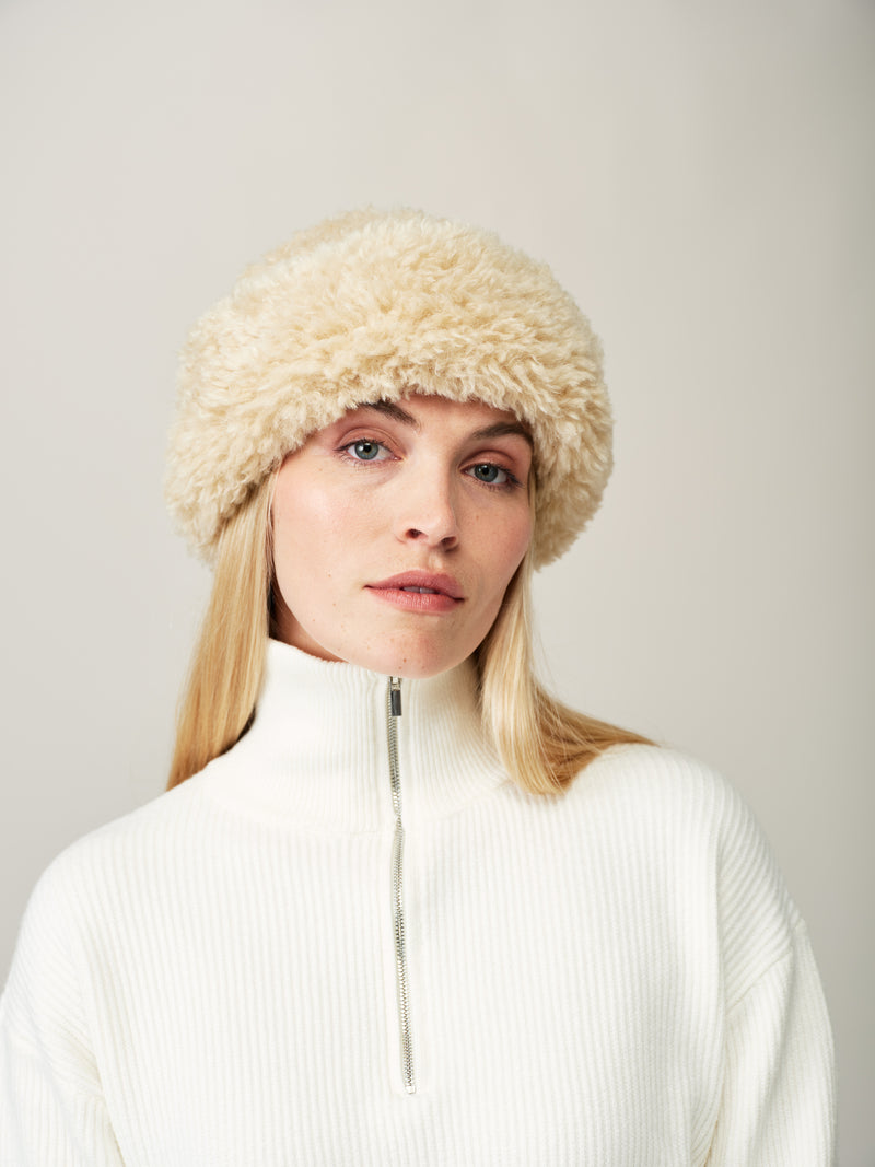 Model wearing the Cream faux sheepskin Sherpa Hat by Helen Moore