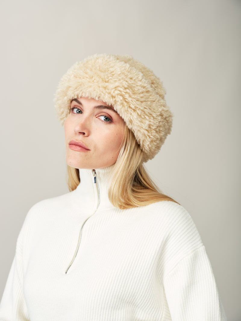 Model wearing the Cream faux sheepskin Sherpa Hat by Helen Moore