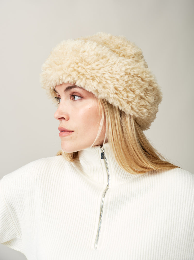 Model wearing the Cream faux sheepskin Sherpa Hat by Helen Moore