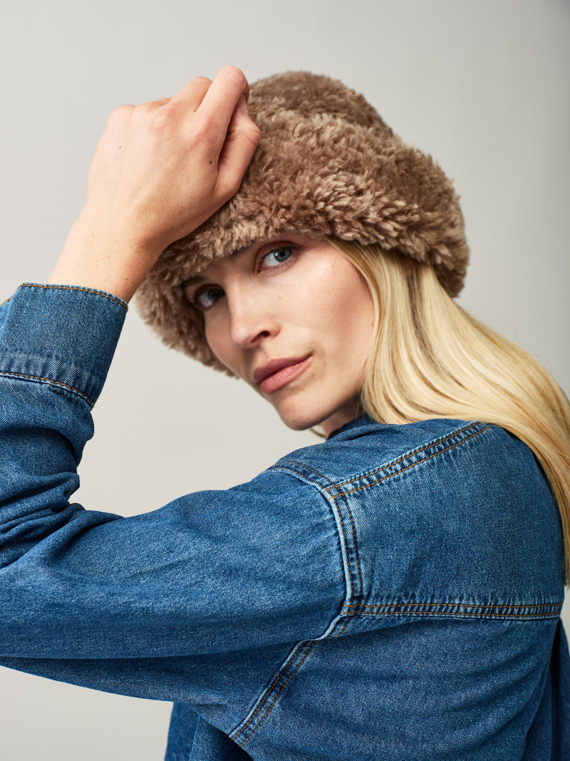 Model wearing the Taupe faux sheepskin Sherpa Hat by Helen Moore