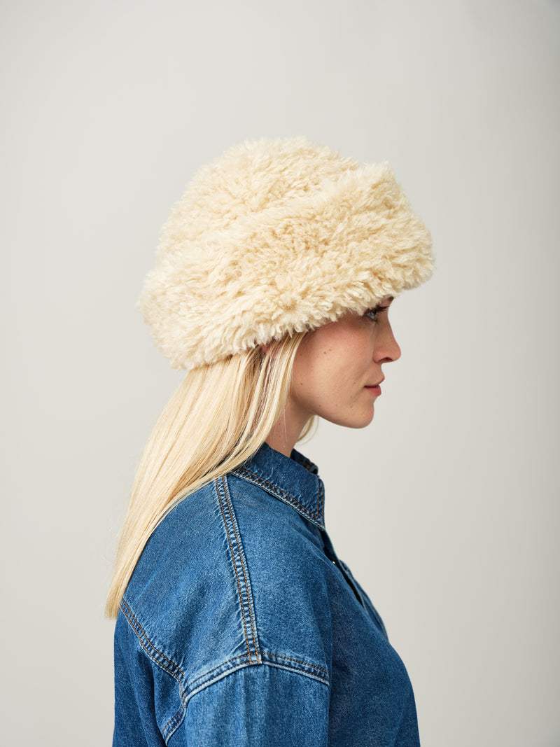 Model wearing the Cream faux sheepskin Sherpa Hat by Helen Moore