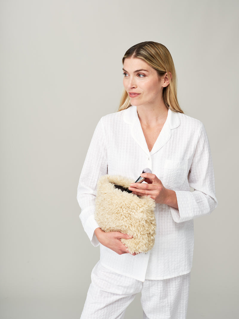 Model holding the large make up bag in Cream faux sheepskin by Helen Moore  