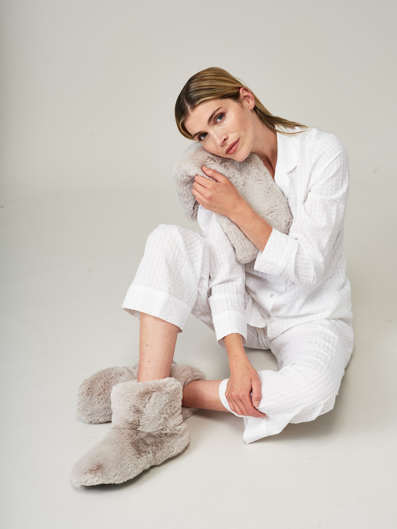 Model holding a Mist Grey faux fur long wheat pillow by Helen Moore